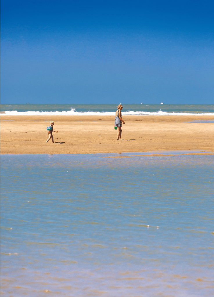 Deux personnes sur un banc de sable sur la plage de Bonne Anse à La Palmyre. Devant les bancs de sables se forment les baïnes.
